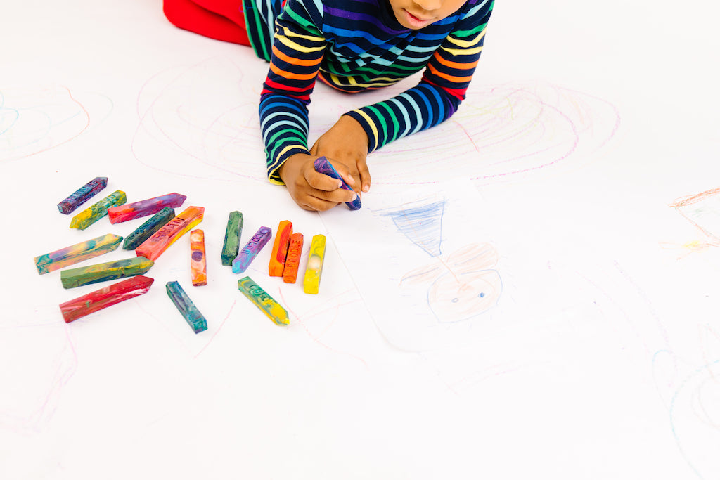 Kid is coloring with a multicolored Crayon Stix from crayon shop Art 2 the Extreme. The entire image is white and the child is cooling directly on the ground with 16 other crayon sticks on the white ground. This is not paint.  See the sellers website or more information about crayon size and small parts.